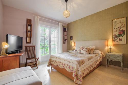 ein Schlafzimmer mit einem Bett und einem Fernseher in der Unterkunft Casa Serrania in Collado Mediano