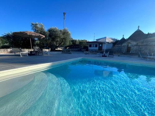 a large swimming pool with blue water at I trulli di Eva in Noci