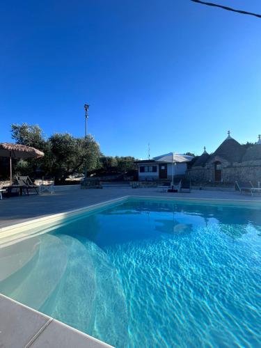 a large swimming pool with blue water at I trulli di Eva in Noci