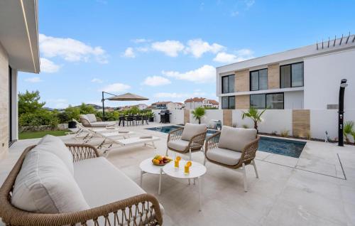 a patio with wicker furniture and a pool at Villa Lux1 Tribunj in Tribunj