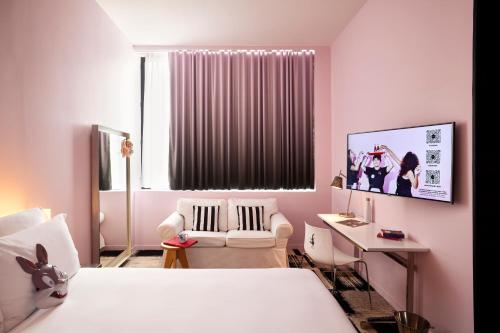 a bedroom with a bed and a chair and a desk at Mama Shelter Bordeaux Centre in Bordeaux