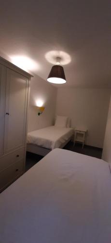 a bedroom with a white bed and a lamp at B&B Domaine du Vieux Chêne in Stoumont