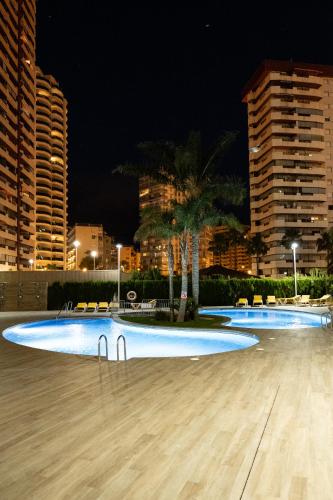 a large swimming pool at night with buildings at Flamenco Ambar Luxury Apartment 15 Planta in Calpe