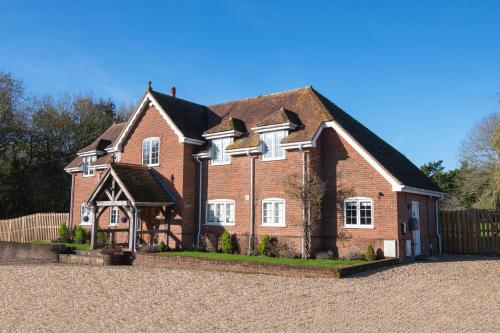 a large red brick house with a fence at Langford farmhouse - New Forest National Park Luxury 4bd, hot tub, cinema, 10 acres in Bartley