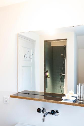 a bathroom sink with a large mirror above a sink at Militärkantine St. Gallen in St. Gallen