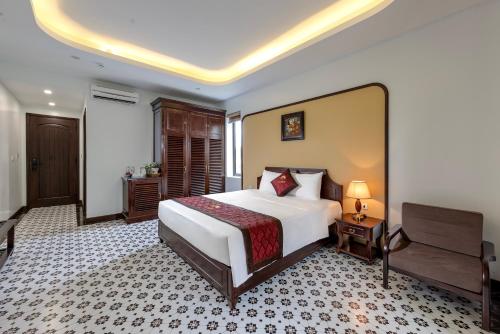 a bedroom with a large white bed and a desk at Le Maison Tam Coc Boutique Hotel in Ninh Binh