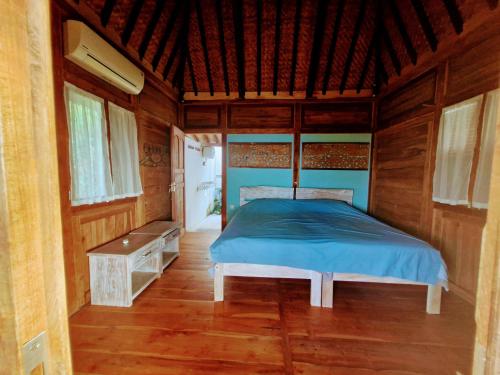 una camera da letto con un letto in una stanza di legno di Villa Bakso Mentigi a Teluknarat