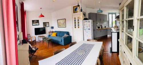 un salon avec une table et un canapé bleu dans l'établissement Charmant F3 duplex 60 M2 à 150m mer, à Saint-Aubin-sur-Mer