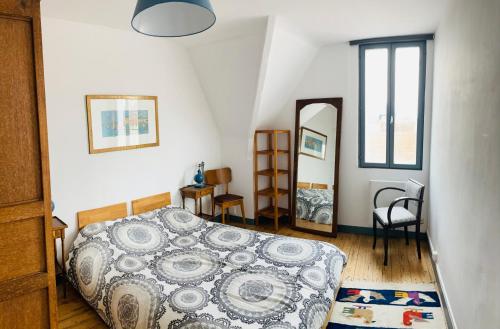 une chambre avec un lit et un miroir dans l'établissement Charmant F3 duplex 60 M2 à 150m mer, à Saint-Aubin-sur-Mer
