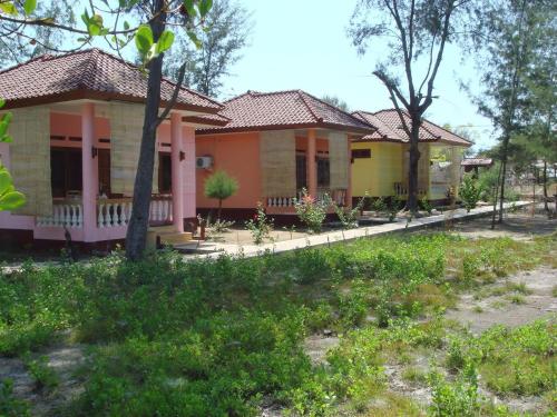a row of cottages with pink and yellow at Kalinka Inn in Gili Meno