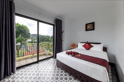 a bedroom with a bed and a large window at Le Maison Tam Coc Boutique Hotel in Ninh Binh