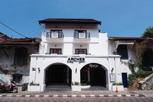 a white building with an arctic pro sign on it at Hotel Arches in Cochin