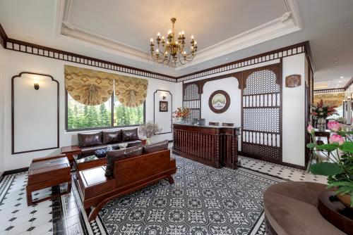 a living room with a couch and a chandelier at Le Maison Tam Coc Boutique Hotel in Ninh Binh
