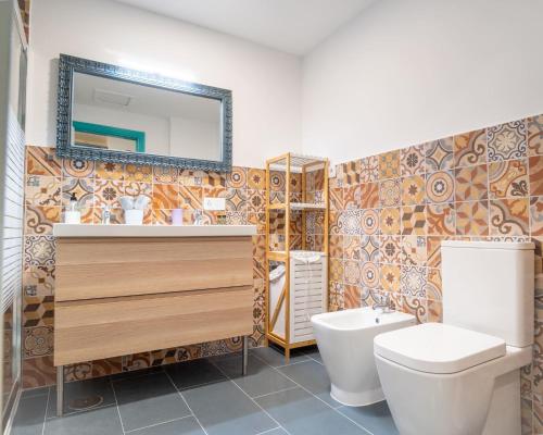 un bagno con un water, un lavandino e uno specchio di B-Rent Perla de Mar a Corralejo