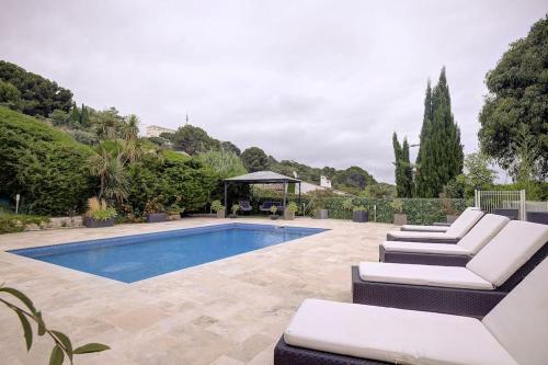 - une piscine avec 2 chaises longues et un kiosque dans l'établissement Twin Luxurious Villas 8 BR Pool in Vallauris, à Vallauris