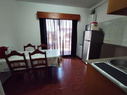 a kitchen with a table and chairs and a refrigerator at Apartamentos Lisboa in Vila do Porto