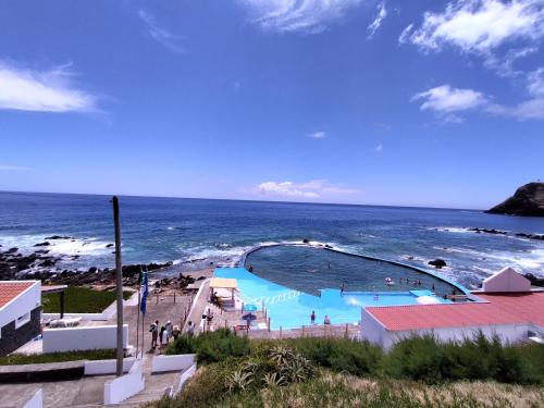 a swimming pool with the ocean in the background at Apartamentos Lisboa in Vila do Porto
