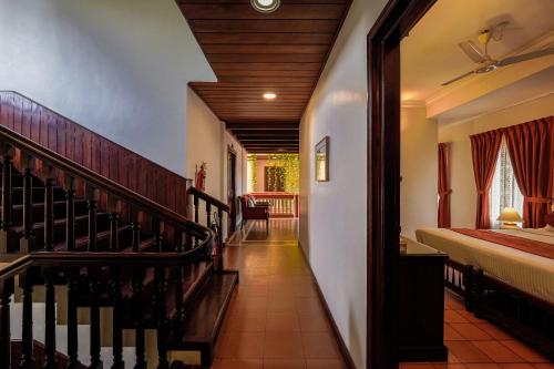 a hallway of a house with a bed and a staircase at Hotel Arches in Cochin