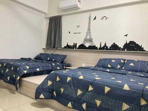 a bedroom with two beds and a mural of the eiffel tower at Happy Homestay TheVenus Sitiawan in Sitiawan