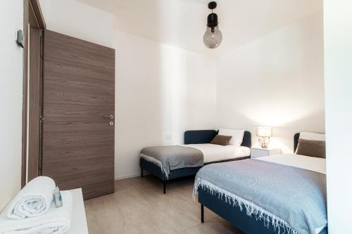 a small room with two beds and a couch at Lario Suite Apartments by Quokka 360 - With parking Next to Como City in Como