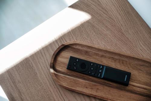 a remote control sitting on top of a wooden table at Lario Suite Apartments by Quokka 360 - With parking Next to Como City in Como