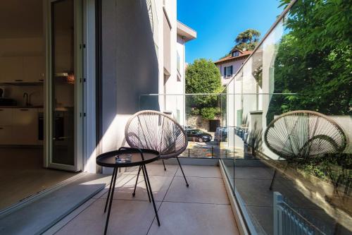 two chairs and a table on a balcony at Lario Suite Apartments by Quokka 360 - With parking Next to Como City in Como