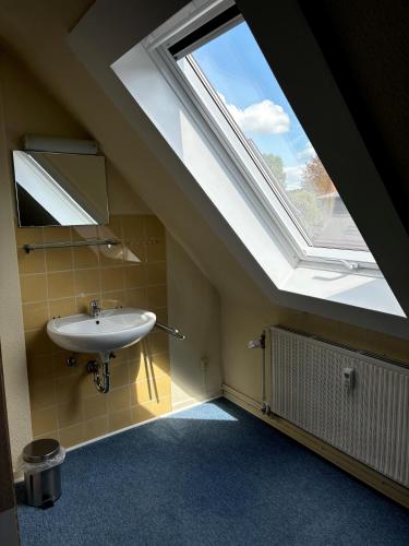 a bathroom with a sink and a large skylight at Pension NentersHaus in Nentershausen