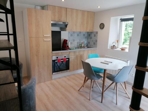 une cuisine et une salle à manger avec une table et des chaises dans l'établissement Gîtes Ferme de la Courbée, à Cherbourg en Cotentin