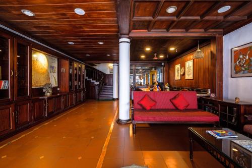 a living room with a red couch and a column at Hotel Arches in Cochin