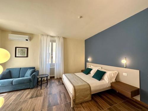 a bedroom with a bed and a blue couch at La Ninfa Hotel in Bagni di Lucca