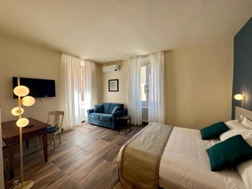 a bedroom with a bed and a desk and a chair at La Ninfa Hotel in Bagni di Lucca