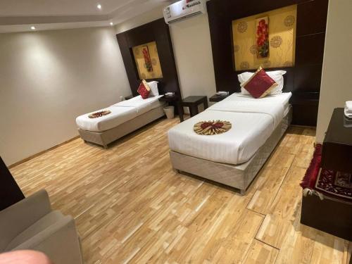 a hotel room with two beds and a couch at أول سويت للشقق المخدومة in Riyadh