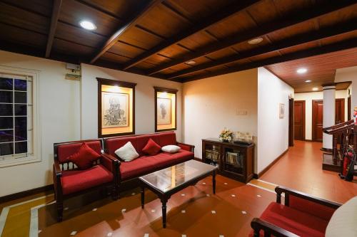 a living room with a red couch and a table at Hotel Arches in Cochin