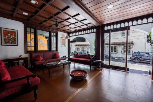 a living room with red couches and tables and windows at Hotel Arches in Cochin