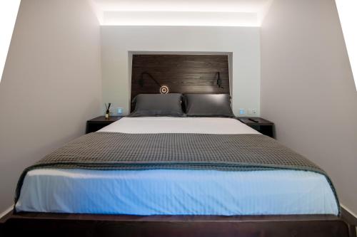 a bedroom with a large bed with a wooden headboard at Sylvia Camping & Luxury Suites, Panel Hospitality Homes & Villas in Litochoro