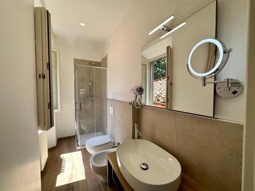 a bathroom with a sink and a toilet and a mirror at La Ninfa Hotel in Bagni di Lucca