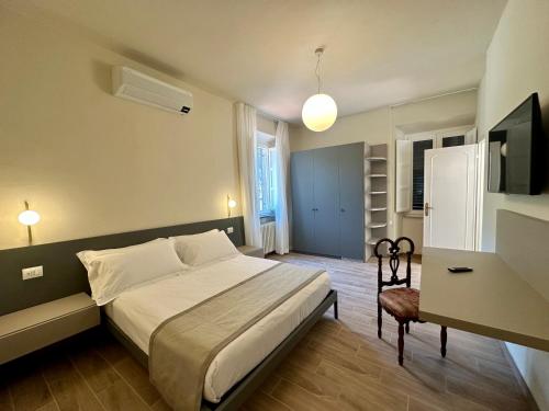 a bedroom with a bed and a desk and a television at La Ninfa Hotel in Bagni di Lucca