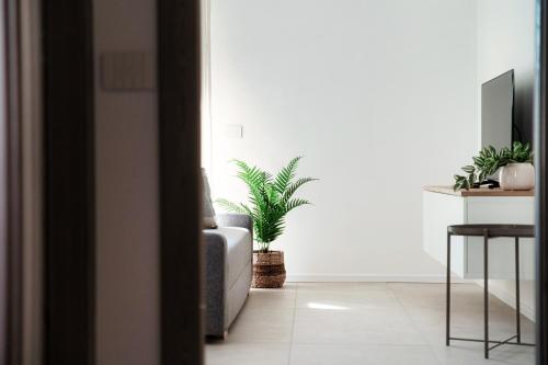 a living room with a couch and a potted plant at Lario Suite Apartments by Quokka 360 - With parking Next to Como City in Como