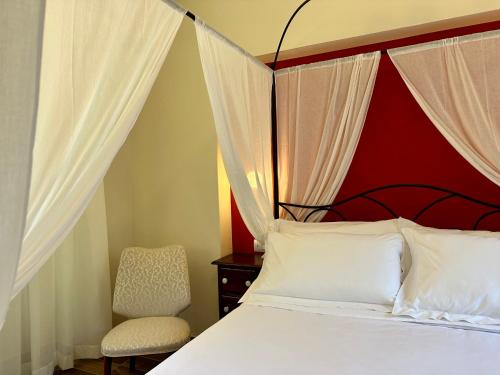 a bedroom with a bed and a chair at La Ninfa Hotel in Bagni di Lucca