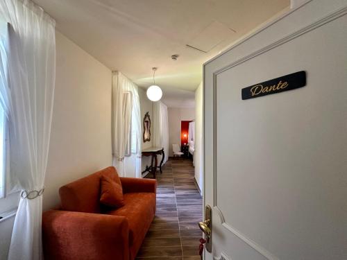 a living room with a chair and a sign on the door at La Ninfa Hotel in Bagni di Lucca
