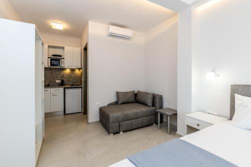 ein Schlafzimmer mit einem Bett und einem Stuhl sowie eine Küche in der Unterkunft INTERNI LUXURY LIVING b in Nikiti