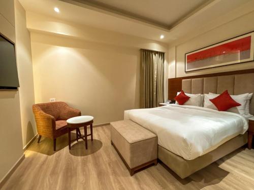 a hotel room with a bed and a chair at Best Western Plus Amritsar in Amritsar