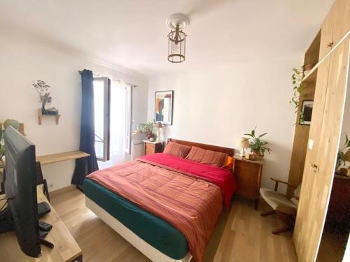 a bedroom with a bed and a television in it at Mosaic Canal - 2 bedrooms flat, 10mn walk to Paris in Pantin