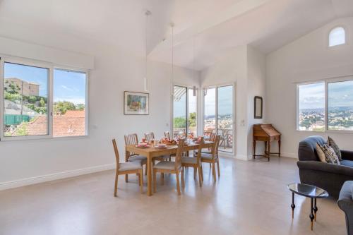 une salle à manger avec une table, des chaises et des fenêtres dans l'établissement #54 Sea view Villa 4 BDR AC Parking 5mins to Port BBQ, à Nice