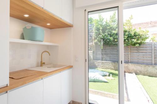 a kitchen with white cabinets and a sliding glass door at #54 Sea view Villa 4 BDR AC 5mins to Port BBQ in Nice