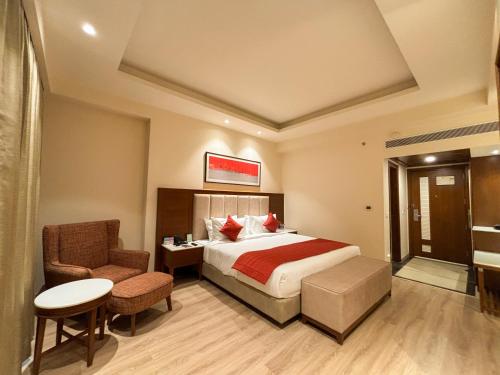 a hotel room with a bed and a chair at Best Western Plus Amritsar in Amritsar