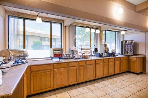 a large kitchen with wooden cabinets and windows at AmericInn by Wyndham La Crosse Riverfront-Conference Center in La Crosse