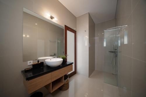 a bathroom with a sink and a glass shower at Best Place Near City Center and Batu Bolong Beach! - It's A 3BDR Villa with Private Pool in Canggu