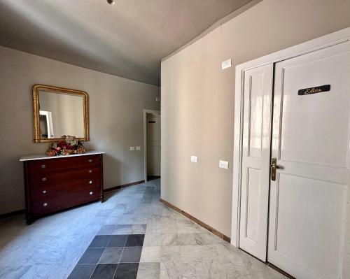 a room with a door and a dresser and a mirror at La Ninfa Hotel in Bagni di Lucca