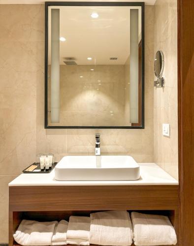 a bathroom with a white sink and a mirror at Best Western Plus Amritsar in Amritsar